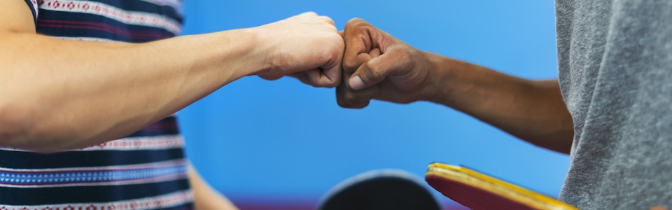 Two people from different cultures doing fist pump